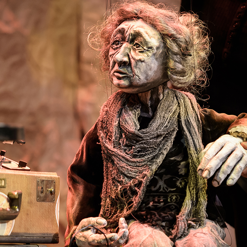 Old woman marionette looking off into distance