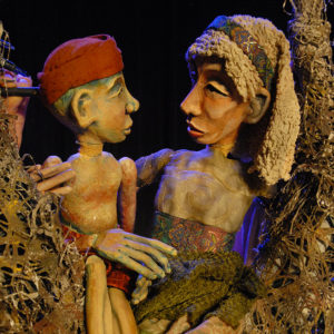 Close-up of mother and son puppets sitting in a tree